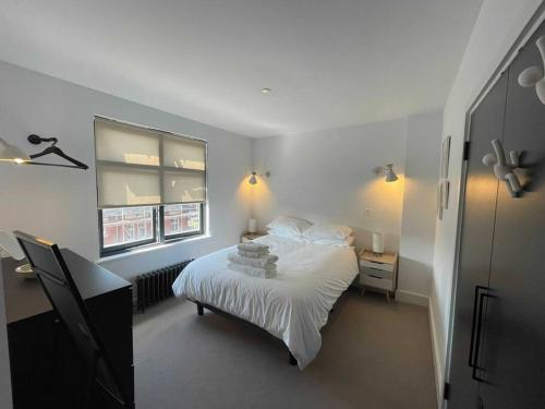 Schlafzimmer mit einem Bett mit weißer Bettwäsche und einem Fenster in der Unterkunft Luxury 1 Bedroom Apartment Lymington, New Forest in Lymington