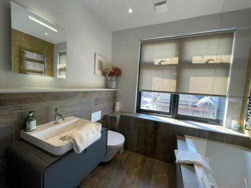 a bathroom with a sink and a tub and a toilet at Luxury 1 Bedroom Apartment Lymington, New Forest in Lymington