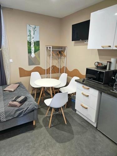 una piccola cucina con letto, tavolo e sedie di Studio Montry a Montry