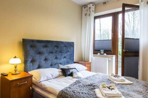 een slaapkamer met een groot bed met een blauw hoofdeinde bij Apartament Cappuccino&Bambusowy in Zakopane
