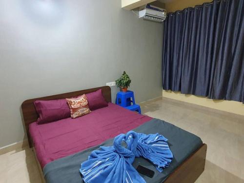 ein Schlafzimmer mit einem Bett mit violetter Bettwäsche und einem Fenster in der Unterkunft (North Goa) Serene 2BHK Retreat in Moira Village in Moira