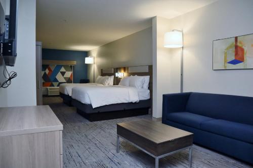 ザカリーにあるHoliday Inn Express Baton Rouge North, an IHG Hotelのホテルルーム(ベッド1台、青いソファ付)