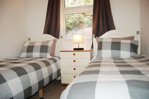 2 letti singoli in una camera da letto con finestra di Bryniau Gwyrdd Chalet 11 Happy Valley a Tywyn