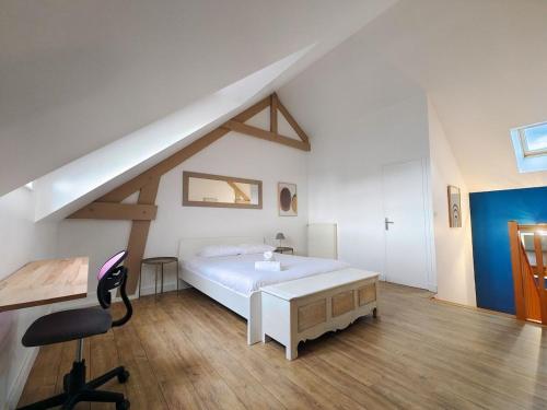 - une chambre avec un grand lit blanc et un bureau dans l'établissement Charmante petite maison en plein centre ville, à Caen