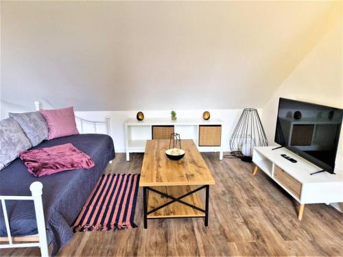 ein Wohnzimmer mit einem blauen Sofa und einem Tisch in der Unterkunft charmantes Landhaus "Wildrose", kurz vor Halle, 4 Schlafzimmer in Petersberg