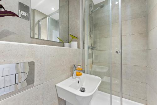 Leek Wootton的住宿－Beautiful 2 Bed Apartment in Warwick - Parking，一间带水槽和玻璃淋浴的浴室