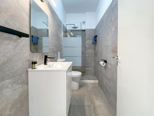 een badkamer met een wastafel, een toilet en een spiegel bij Phaedrus Living: Ourania City Heights Flat in Limassol