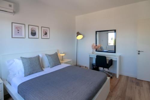 1 dormitorio con cama, escritorio y espejo en Phaedrus Living: Ourania City Heights Flat, en Limassol