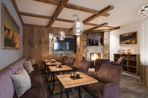 a restaurant with couches and tables and a fireplace at Hotel Seespitz in Ischgl