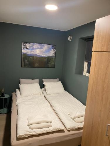 a bedroom with two beds with white sheets at Fin leilighet i Tromsø in Tromsø