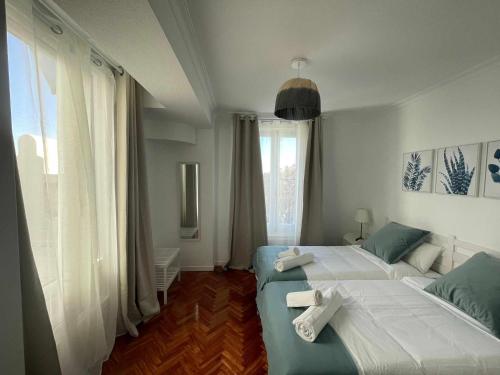 um quarto com 2 camas e uma grande janela em Apartamento con terraza y vistas AlcaláRetiro em Madri