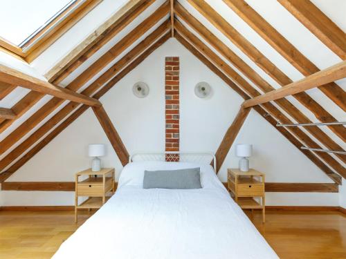 sypialnia z białym łóżkiem na poddaszu w obiekcie The Courtyard w mieście Pulborough