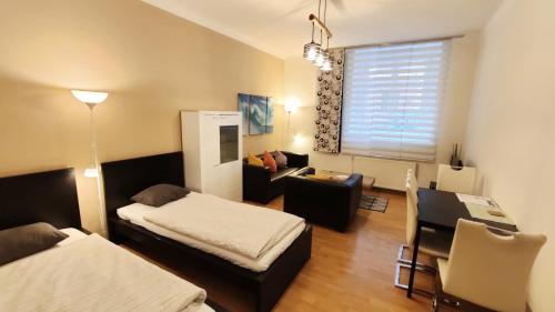 プラハにあるStyle Apartmentのベッド2台、デスク、窓が備わる客室です。