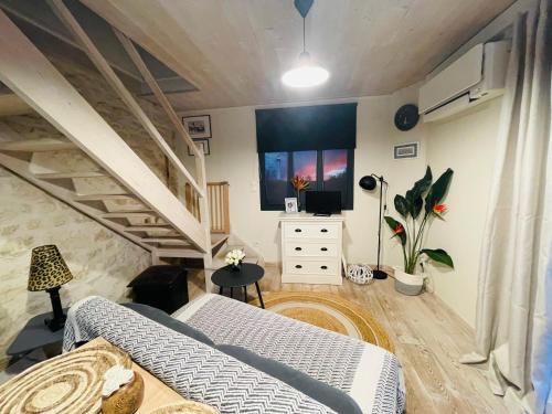 - un salon avec un canapé et une télévision dans l'établissement Petite Maison des Renaudins, à Taillebourg