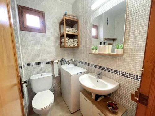 卡拉恩布拉內斯的住宿－Macarella Apatamento con piscina，浴室配有白色卫生间和盥洗盆。