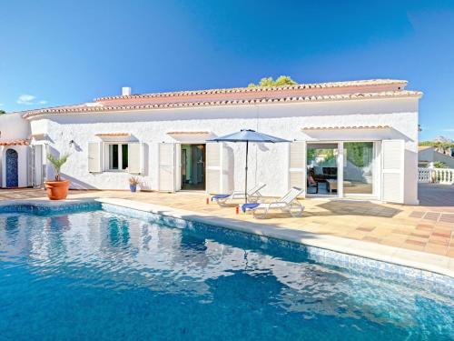 a villa with a swimming pool in front of a house at Villa Batavia by Interhome in Balcon del Mar