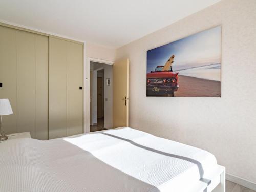 ル・ラヴァンドゥーにあるApartment Cadet Rousse-6 by Interhomeのベッドと赤いトラックの絵が飾られた寝室
