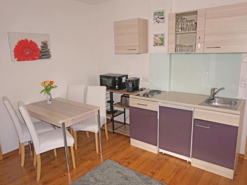 uma pequena cozinha com uma mesa e um lavatório em Apartment Muehlbach by Interhome em Fliess