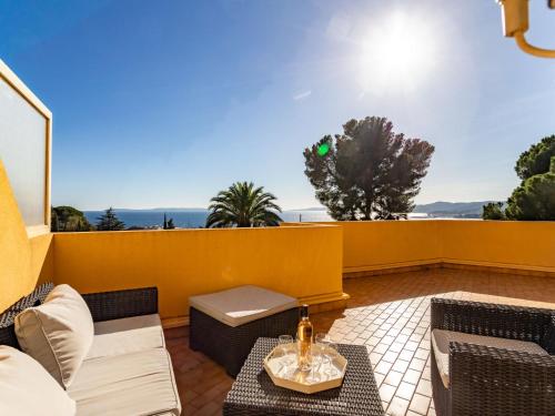 a patio with furniture and a yellow wall at Apartment Cadet Rousse by Interhome in Le Lavandou