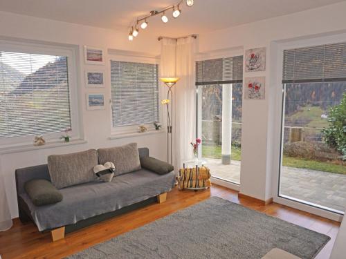 uma sala de estar com um sofá e duas janelas em Apartment Muehlbach by Interhome em Fliess