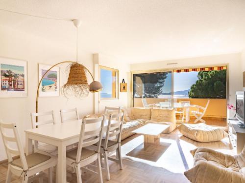 a dining room and living room with a table and chairs at Apartment Cadet Rousse-6 by Interhome in Le Lavandou