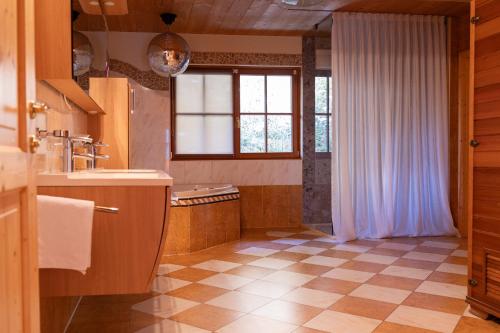 a large bathroom with a sink and a window at Almgasthof Windischgrätz in Bad Gastein