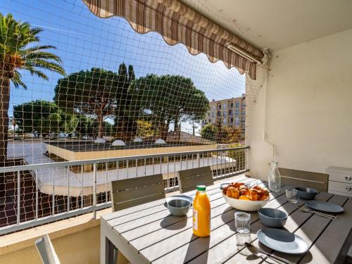 - une table avec un bol de fruits et une grande fenêtre dans l'établissement Apartment La Méridienne-3 by Interhome, au Lavandou