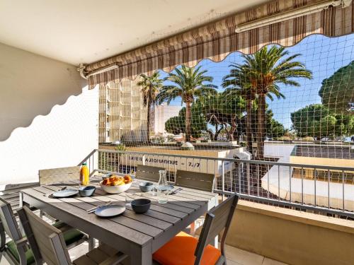 d'une table sur un balcon avec vue sur les palmiers. dans l'établissement Apartment La Méridienne-3 by Interhome, au Lavandou