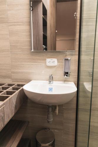 a bathroom with a white sink and a mirror at Hotel Boutique Business Center in Cali