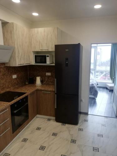 uma cozinha com um frigorífico preto num quarto em VIP apart 505 em Tsqnetʼi