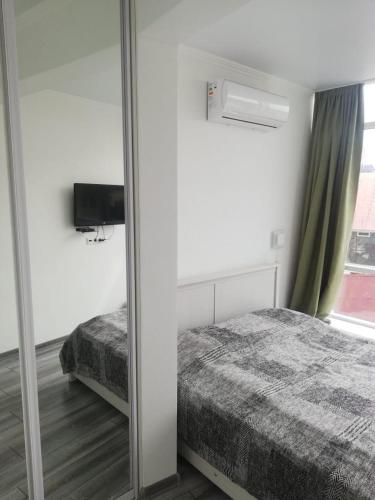 1 dormitorio con espejo junto a la cama en VIP apart 505 en Tsqnetʼi