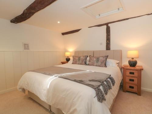 a bedroom with a large bed and two lamps at The Hayloft in Honiton