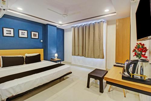 ein Schlafzimmer mit einem Bett und einer blauen Wand in der Unterkunft Super OYO SilverKey 79803 Qualia Miyapur in Kondapur