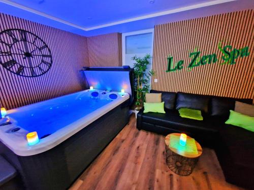 a large blue tub in a room with a couch at -Le Zen Spa+Jacuzzi+Parking+Clim in Colmar