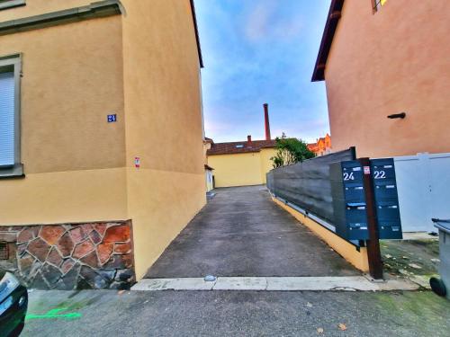 an alley way between two buildings with a fence at ZEN SPA-4 Pers-Jacuzzi-Parking-Clim-Colmar in Colmar