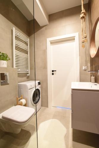a bathroom with a toilet and a washing machine at Apartament Wisła Siglany in Wisła