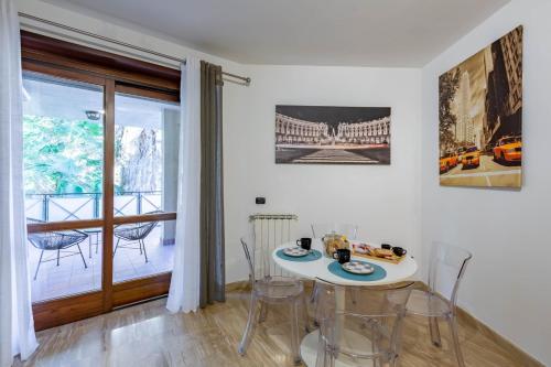 a dining room with a table and chairs and a balcony at LU Apartment Eur in Rome