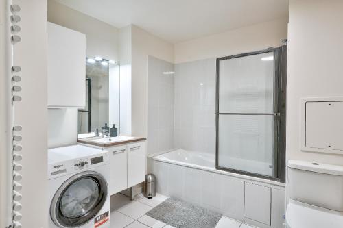 une salle de bain blanche avec une machine à laver à l'intérieur dans l'établissement Chill & Work au pied de La Défense Arena, à Nanterre