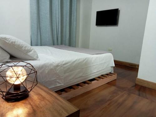 a bedroom with a bed and a table with a lamp at Cómodo apartamento in Jericó