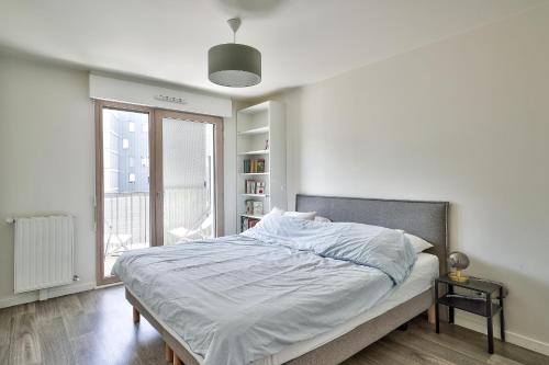 une chambre blanche avec un lit et une fenêtre dans l'établissement Chill & Work au pied de La Défense Arena, à Nanterre