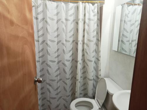 a bathroom with a toilet and a shower curtain at Cómodo apartamento in Jericó