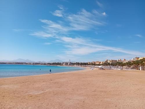 a person standing on a beach near the water at Sahl Hasheesh, El Andalous by All View apartements in Hurghada