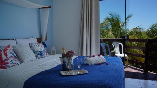 a bedroom with a bed with a table with a blue blanket at Hotel Liberdade Búzios in Búzios