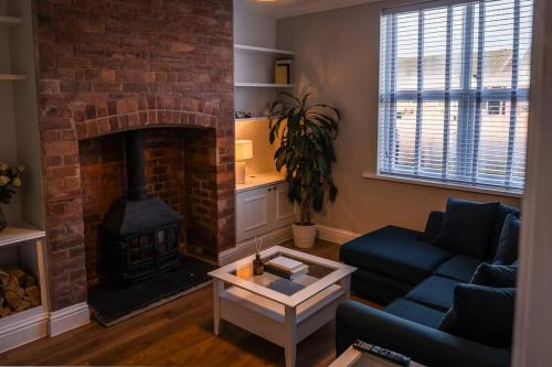 a living room with a fireplace and a blue couch at Renovated 3 Bedroom House in Lowton Pennington in Leigh