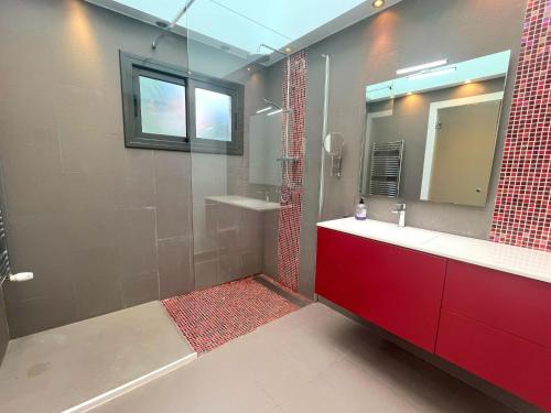 a bathroom with a red sink and a mirror at Espectacular casa de diseño alto standing in Alella