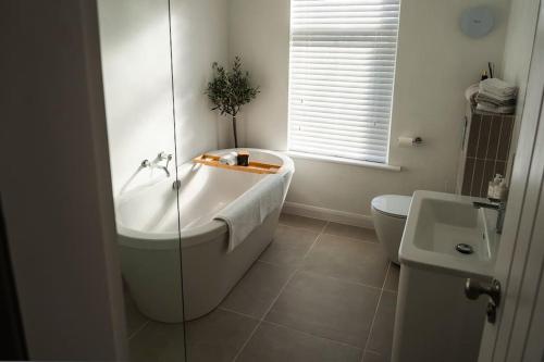 uma casa de banho com uma banheira, um WC e um lavatório. em Renovated 3 Bedroom House in Lowton Pennington em Leigh