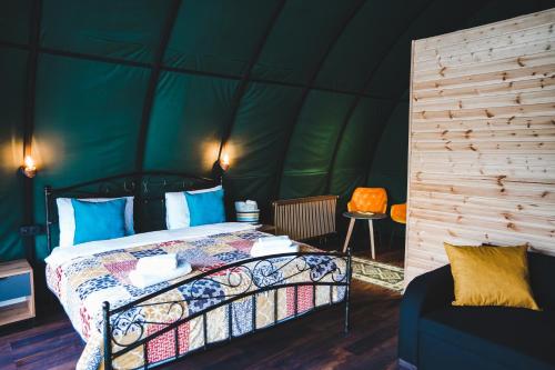 卡茲別吉的住宿－Kuro Glamping，绿色帐篷内一间卧室,配有一张床
