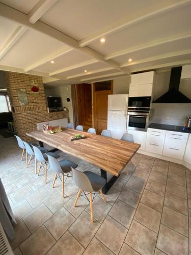 una cocina con una gran mesa de madera y sillas en Chalet 't Vraagteken, en Durbuy