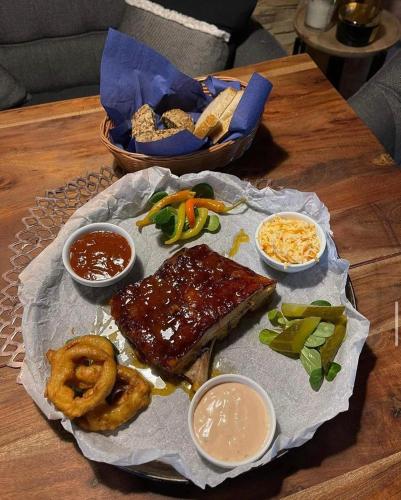 a plate of food with meat and onion rings on a table at Hotel Taurus in Ostrava