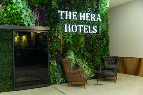 a green wall with two chairs and a hotel sign at The Hera Business Hotels & Spa in Istanbul